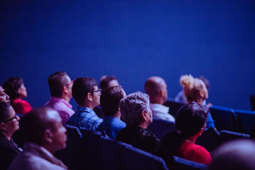 Small audience seated in a dimly lit conference room, illustrating how few people a narrow B2B LinkedIn targeting filter actually reaches