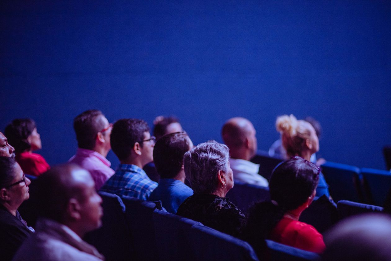 Small audience seated in a dimly lit conference room, illustrating how few people a narrow B2B LinkedIn targeting filter actually reaches