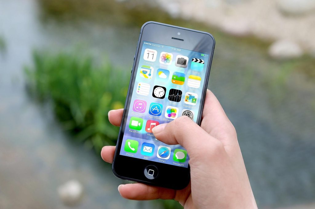 Hand holding a smartphone showing a full grid of app icons, illustrating the range of placements Meta's system can now choose from