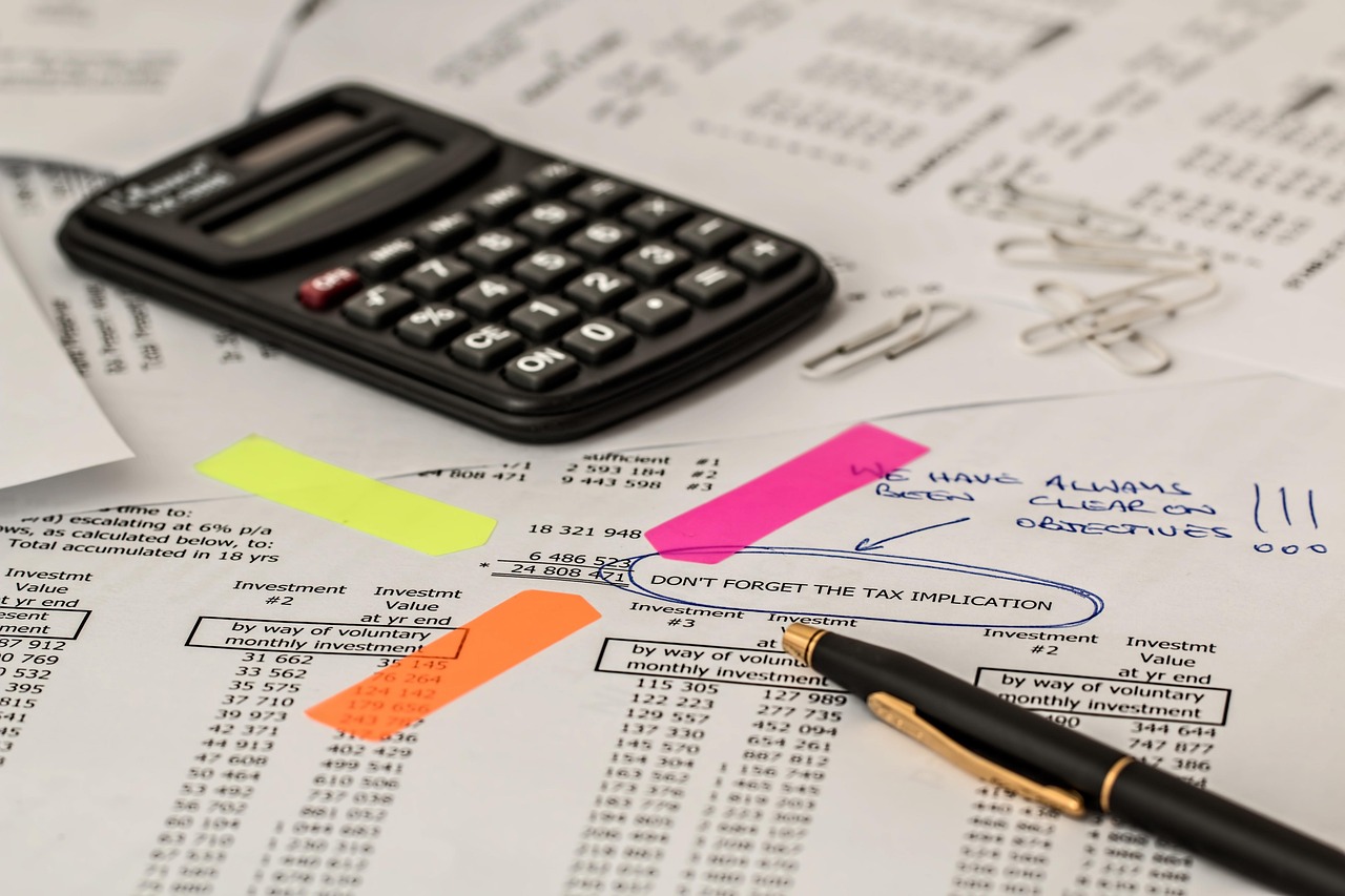Pocket calculator and pen resting on a highlighted printed financial statement, illustrating the margin arithmetic a peer-spend benchmark leaves out