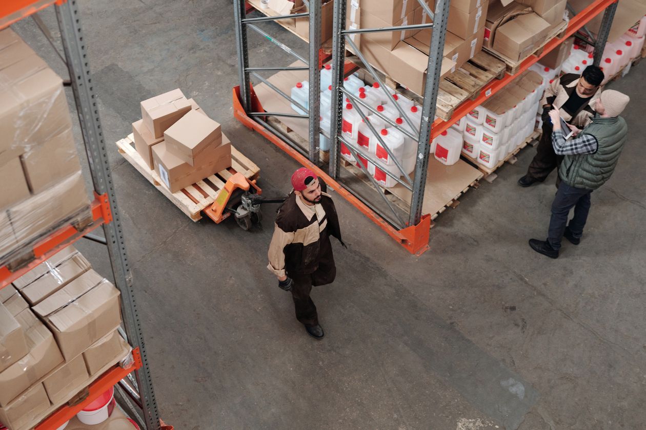 Warehouse workers moving pallets of boxed stock on a distribution floor, the backend order record that now overrides a website tag’s conversion values
